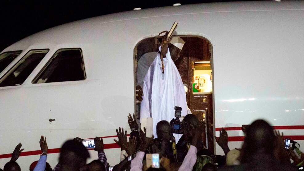 L’ex-président gambien Yahya Jammeh salue ses partisans avant d’entrer à bord de l’avion en destination de la Guinée équatoriale, à l’aéroport de Banjul, Gambie, 21 janvier.