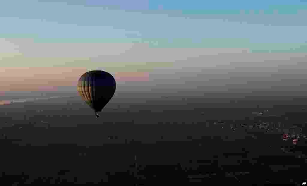 Perjalanan balon udara sebelum matahari terbit di Luxor, Mesir (23 November 2012). 