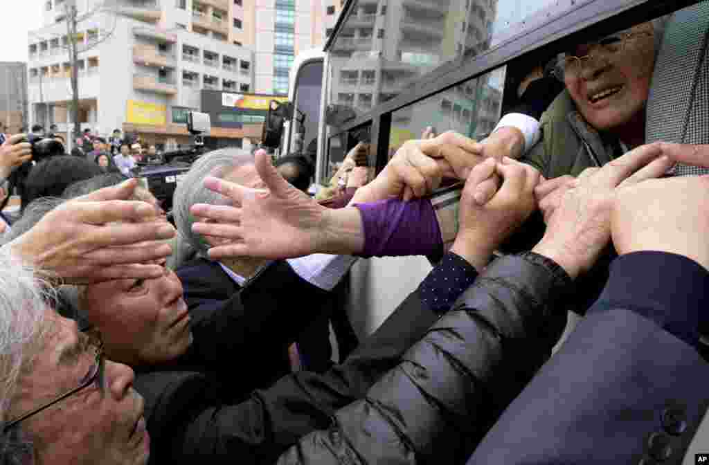 Người Bắc Triều Tiên trên xe buýt cố nắm tay người thân trong những giây phút cuối cùng trước khi chia tay sau cuộc đoàn tụ gia đình ở khu du lịch Núi Kim Cương ở Bắc Triều Tiên, ngày 22/10/2015.