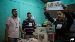 FILE - An electoral worker shows a ballot marked to Opposition Alliance presidential candidate Salvador Nasralla during the vote count in the general elections in Tegucigalpa, Honduras, Nov. 26, 2017.
