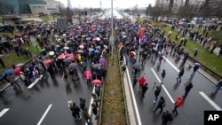 Protesters stand on the highway during a protest in Belgrade, Serbia, Dec. 11, 2021.