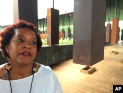 Toni Battle stands inside a display at the National Memorial for Peace and Justice, a new memorial to honor thousands of people killed in racist lynchings, which opened to the public, April 26, 2018, in Montgomery, Ala.