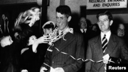 In this August 8, 1953 file photo, Sir Edmund Hillary, left, and his fellow New Zealander George Lowe, are welcomed home to New Zealand following their arrival by air at Auckland. 