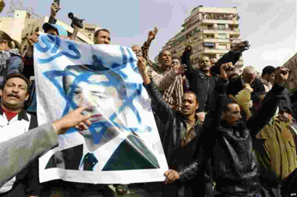 Egyptian protesters shout anti-Mubarak slogans as they flash a poster showing Mubarak framed on the Star of David during a protest in Tahrir square in Cairo, Egypt, Friday, Feb.4, 2011. The Egyptian military guarded thousands of protesters pouring into Ca