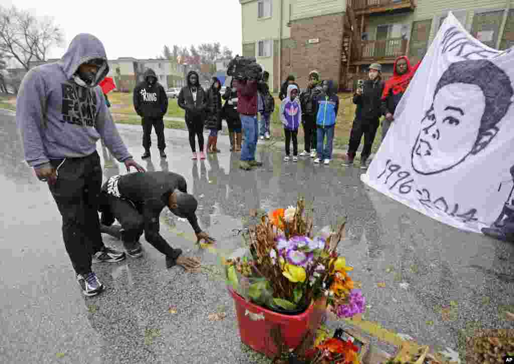 Ray Mills, à esquerda, e Londrelle Hall parados em frente ao memorial colocado no meio da estrada este Domingo, 23, mais de três meses depois de um jovem negro de 18 anos ter sido morto a tiro por um polícia branco em Ferguson, Missouri. Novembro, 2014.