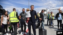 Toni Kroos, joueur de l'équipe nationale allemande de football, porte sa fille après son atterrissage à l'aéroport de Francfort-sur-le-Main, Allemagne, 28 juin 2018.
