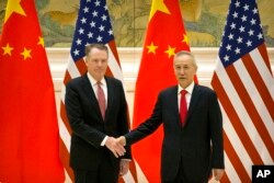 U.S. Trade Representative Robert Lighthizer, left, and Chinese Vice Premier and lead trade negotiator Liu He shake hands before the opening session of trade negotiations at the Diaoyutai State Guesthouse in Beijing, Feb. 14, 2019.