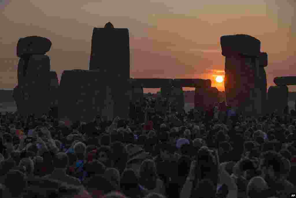 The sun rises as thousands of revelers gathered at the ancient stone circle Stonehenge, near Salisbury, England, to celebrate the summer solstice, the longest day of the year, June 21, 2014.