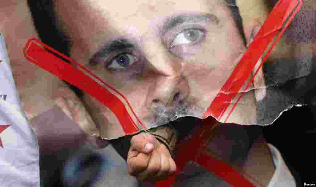 Un manifestante rompe un cartel con la foto del dictador Bashar al-Assad, durante una protesta frente a la embajada de Siria en Londres.