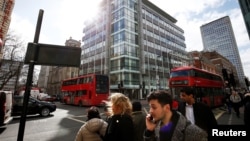 Para pejalan kaki melintas gedung tempat kantor Cambridge Analytica di tengah Kota London, 20 Maret 2018. 