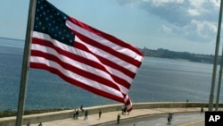 FILE - The U.S. flag waves outside the U.S. Embassy, overlooking Havana's seaside boulevard, the Malecon in Cuba.