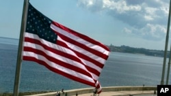 FILE - The U.S. flag waves outside the newly opened U.S. Embassy, overlooking Havana's seaside boulevard, the Malecon in Cuba, Aug. 14, 2015. 