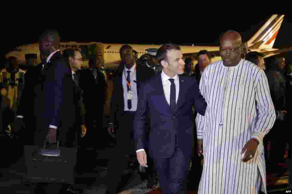 Le président français Emmanuel Macron est accueilli à l'aéroport de Ouagadougou par le président du Burkina Faso, Roch Marc Christian Kabore au Burkina Faso, le 27 novembre 2017.