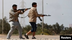 FILE - Fighters from Misrata fire weapons at Islamic State militants near Sirte, March 15, 2015. Militants loyal to Islamic State, the group that has seized much of Iraq and Syria, have established a larger presence in Libya.