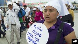 A woman marches carrying a placard calling for a dignified treatment to migrants during a demonstration ahead of the International Day of the Migrant in a populous district in southern Lima, December 15, 2011.