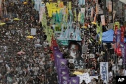 FILE - Protesters carry a large image of jailed Chinese Nobel Peace laureate Liu Xiaobo as they march during a pro-democracy protest in Hong Kong, July 1, 2017.