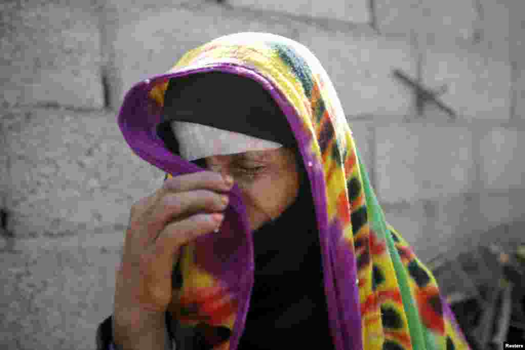 예멘 수도 사나에서 사우디아라비아의 공습으로 집이 파괴된 여성이 울고 있다.