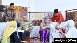 Perdana Menteri Singapura Lee Hsien Loong dan istri Ho Ching mencoba menuliskan pola batik di atas kain mori disaksikan Presiden Jokowi dan Ibu, 14 November 2016 (Foto: VOA/Andylala)