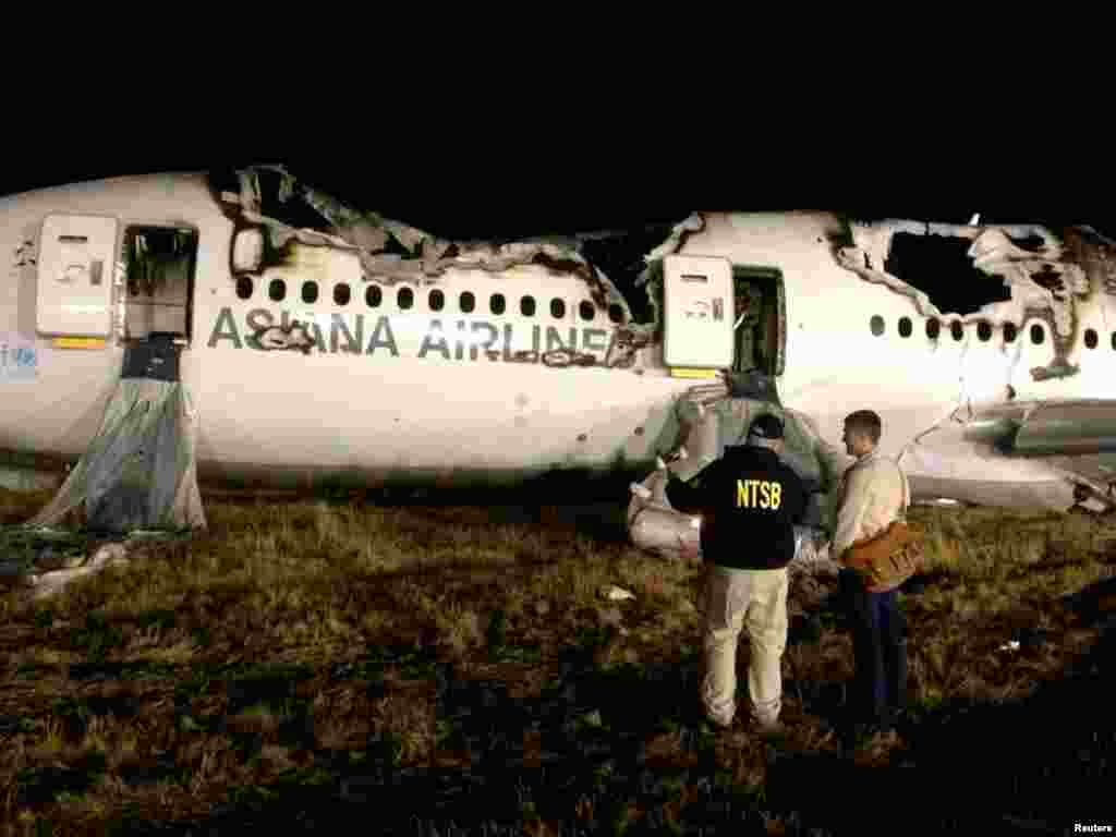 National Transportation Safety Board investigators assess the wreckage of Asiana Airlines Flight 214, at San Francisco International Airport in San Francisco, California.