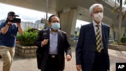 Pro-democracy lawmaker Martin Lee, center, and Albert Ho arrive at a court in Hong Kong Thursday, April 1, 2021. (AP Photo/Vincent Yu)