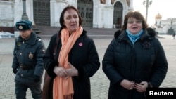 Police escort university professors Yelena Volkova (C) and Irina Karatsuba (R) after detaining them inside the Christ the Saviour Cathedral in Moscow, February 21, 2013.