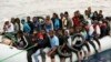 Des migrants sont ramenés sur le rivage après avoir été interceptés par les garde-côtes libyens en mer Méditerranée, à Garaboli, en Libye, le 18 octobre 2021.