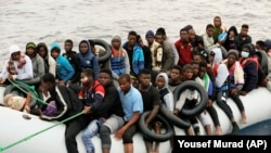 Des migrants sont ramenés sur le rivage après avoir été interceptés par les garde-côtes libyens en mer Méditerranée, à Garaboli, en Libye, le 18 octobre 2021.