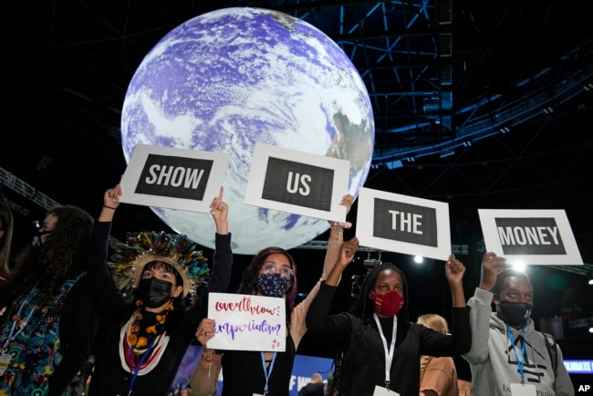 Climate activist Vanessa Nakate, second right, and other activists engage in a 'Show US The Money' protest at the COP26 U.N. Climate Summit in Glasgow, Scotland, Nov. 8, 2021.