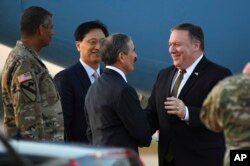 U.S. Secretary of State Mike Pompeo, right, is greeted by U.S. Ambassador to South Korea Harry Harris upon his arrival at Osan Air Base in Pyeongtaek, in South Korea, Sunday, Oct. 7, 2018, after his North Korea trip.