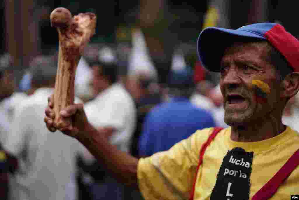 En las protestas de este sábado, en Caracas, Venezuela, un hombre muestra un hueso, como denuncia contra el hambre en el país. Fotos: Fabiana Rondón / VOA.