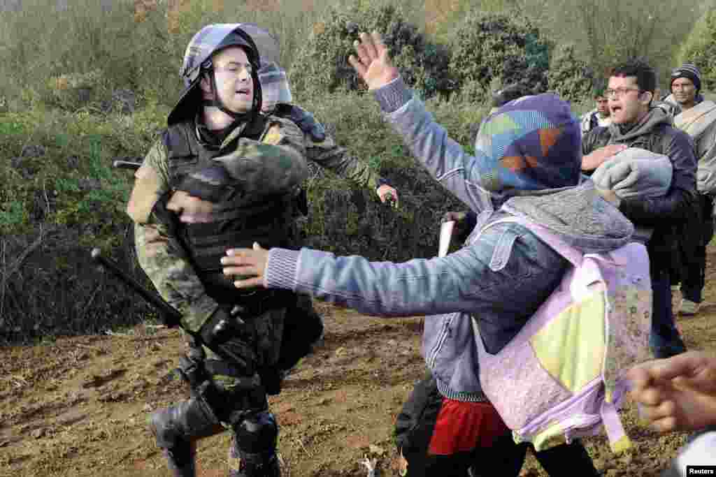 A Macedonian police officer hits a stranded migrant attempting to cross the Greek-Macedonian border, near Gevgelija, Macedonia.