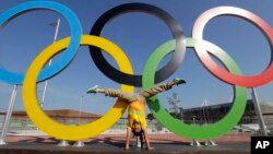 Devojčica pravi "zvezdu" ispred olimpijskih krugova u Olimpijskom parku u Riju