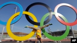 FILE - Leidy Romero Alarcon of Colombia does a handstand in front of the Olympic Rings in Rio de Janeiro, Brazil, Aug. 5, 2016.