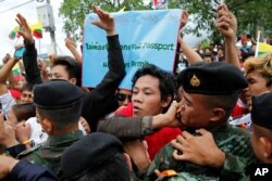 Migrant workers supporting Myanmar Foreign Minister and State Counselor Aung San Suu Kyi push against a line of Thai soldiers to see her past during a meeting at the coastal fishery centre of Samut Sakhon, Thailand, June 23, 2016.