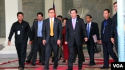 Cambodia's Priminister Hun Sen (R) with Sam Rainsy (L) president of the Cambodia National Rescue Party (CNRP) walk out of the National Assembly after voting for National Election Committee members, in Phnom Penh, Cambodia on April 9th, 2015. (Nov Povleakhena/VOA Khmer) 