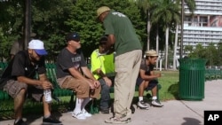 In this frame made from video Sept. 8, 2017, an official in Miami speaks with homeless people about moving to shelters ahead of powerful Hurricane Irma.