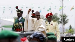 Nigeria's new President Muhammadu Buhari rides on the motorcade while inspecting the guard of honor at Eagle Square in Abuja, Nigeria, May 29, 2015. 