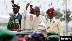 Nigeria's new President Muhammadu Buhari rides on the motorcade while inspecting the guard of honor at Eagle Square in Abuja, Nigeria, May 29, 2015. 