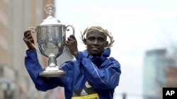 Lawrence Cherono soulève le trophée du marathon de Boston, USA, le 15 avril 2019. (AP Photo/Winslow Townson)