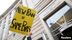 FILE - Immigration activists rally against the Trump administration's new ban against travelers from six Muslim-majority nations, outside of the U.S. Customs and Border Protection headquarters in Washington, March 7, 2017.