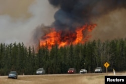 A wildfire burns as evacuees who were stranded north of Fort McMurray, Alberta, Canada head south of Fort McMurray on Highway 63, May 6, 2016.