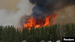 Un feu de forêt brûle pendant que des personnes évacuées ont été bloqués au nord de Fort McMurray, en Alberta sur la route 63 , le 6 mai 2016 