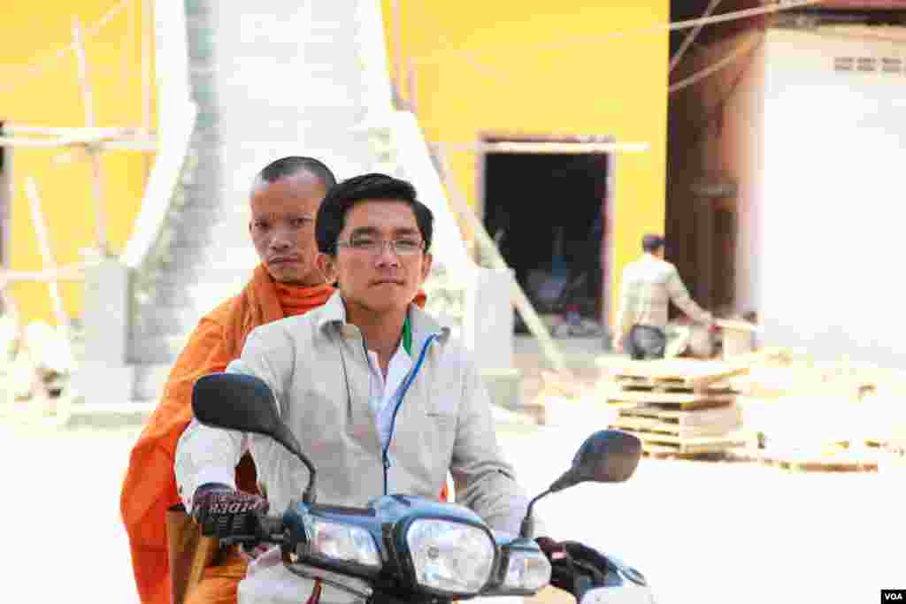 A monk and a man is riding his motor out of the Samakki Raingsey pagoda on 5th February 2015. (Nov Povleakhena/VOA Khmer)