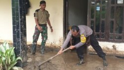 Petugas TNI dan Polisi yang sedang melakukan pembersihan lumpur dari rumah seorang warga yang terdampak banjir bandang di desa Bolapapu, Kulawi, Sigi, Sulawesi Tengah, 13 Desember 2019. (Foto: VOA/Yoanes Litha)