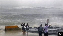 People stand at the end of a street looking at a stormy Atlantic Ocean as Hurricane Irene arrives, in Cape May, New Jersey, August 27, 2011
