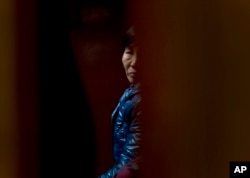 A Chinese relative of passengers aboard a missing Malaysia Airlines plane looks out as she waiting for the latest news inside a hotel room for relatives or friends of passengers aboard the missing airplane in Beijing, China, March 11, 2014.