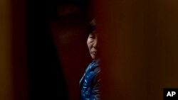 A Chinese relative of passengers aboard a missing Malaysia Airlines plane looks out as she waiting for the latest news inside a hotel room for relatives or friends of passengers aboard the missing airplane in Beijing, China, March 11, 2014.