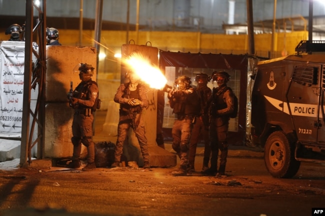 Tentara IDF menembakkan gas air mata ke arah demonstran Palestina selama protes anti-Israel atas ketegangan di Yerusalem, di pos pemeriksaan Qalandiya antara Ramallah dan Yerusalem, di Tepi Barat yang diduduki, pada 11 Mei 2021. (Foto: AFP)