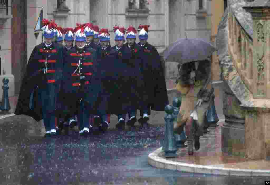 Guardsman arrive in the rain at the cathedral in Monaco before the mass for the National Day.