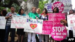 FILE - Supporters of Women's Rights and LGBT groups protest near the Beverly Hills Hotel, owned by the Sultan of Brunei, demanding an end toTaliban-like Brunei penal code which included stoning gay men and lesbians to death and public flogging, May 5, 2014.